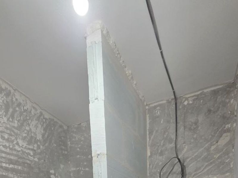 Walls stripped back to the substrate before plastering during a Prague flat renovation