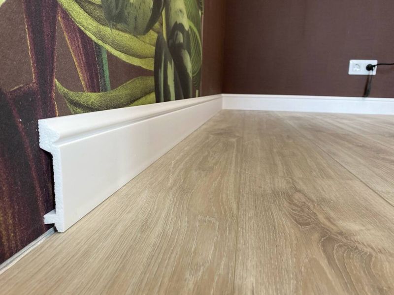 Oak-look flooring with a white skirting board