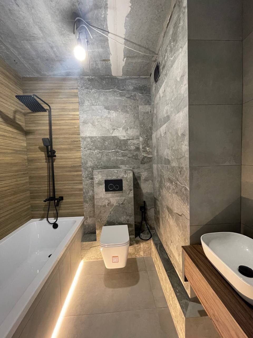 Bathroom with wood decor and LED lighting under the bathtub after renovation
