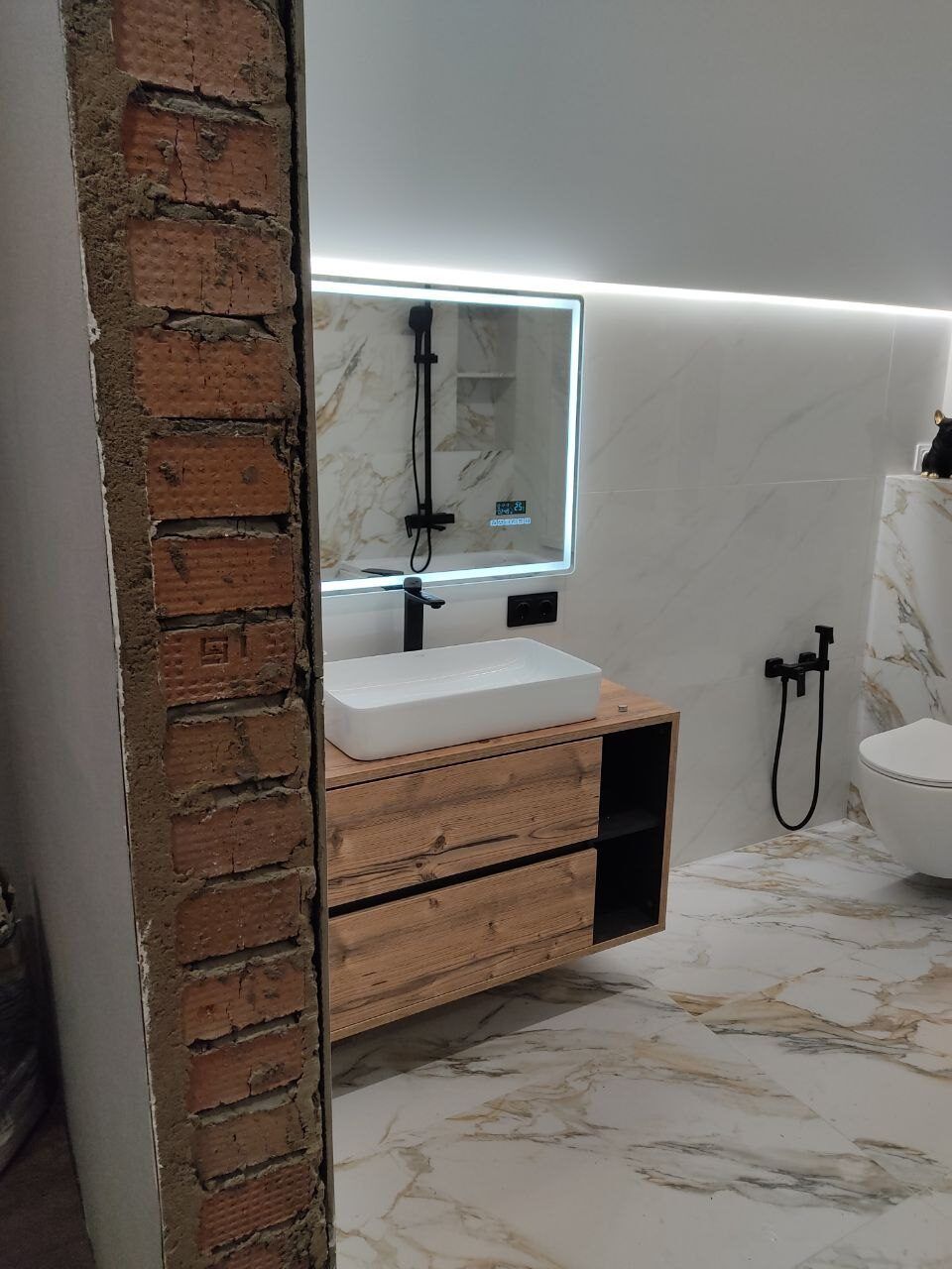 Loft-style bathroom with a brick wall and a wooden vanity unit