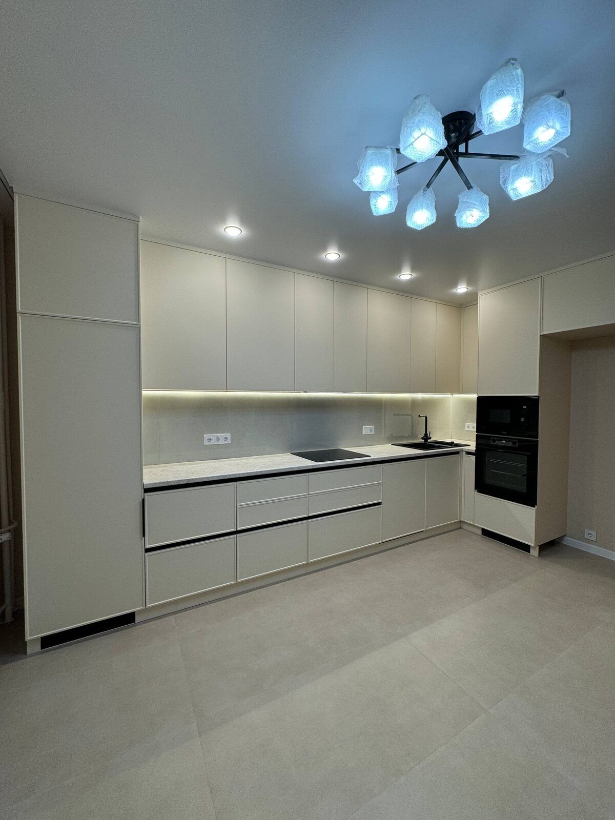 Long white kitchen with LED worktop lighting