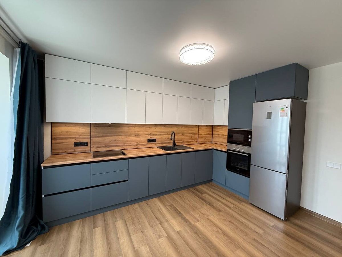 Blue-grey kitchen with a wooden worktop after a flat renovation