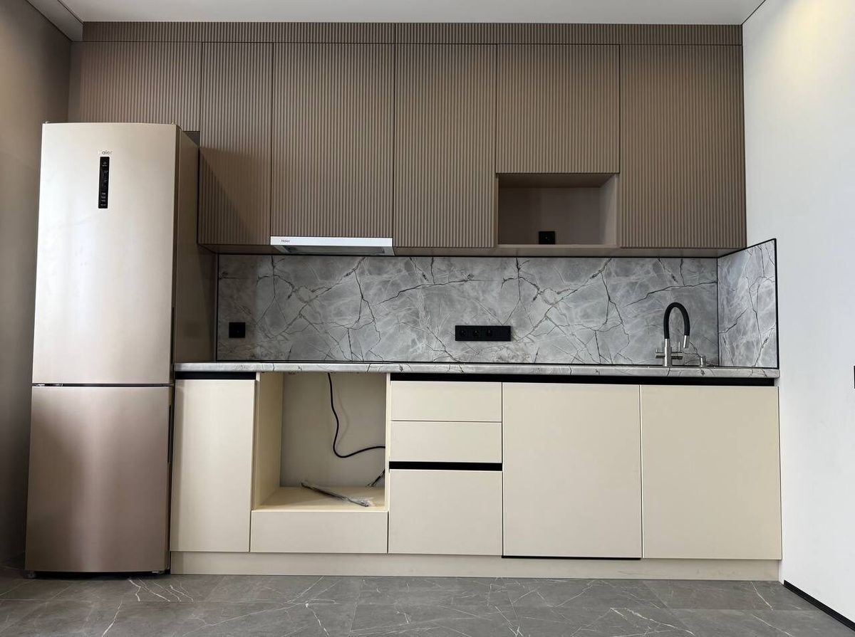 White kitchen with wooden details and a stone splashback after renovation, Prague
