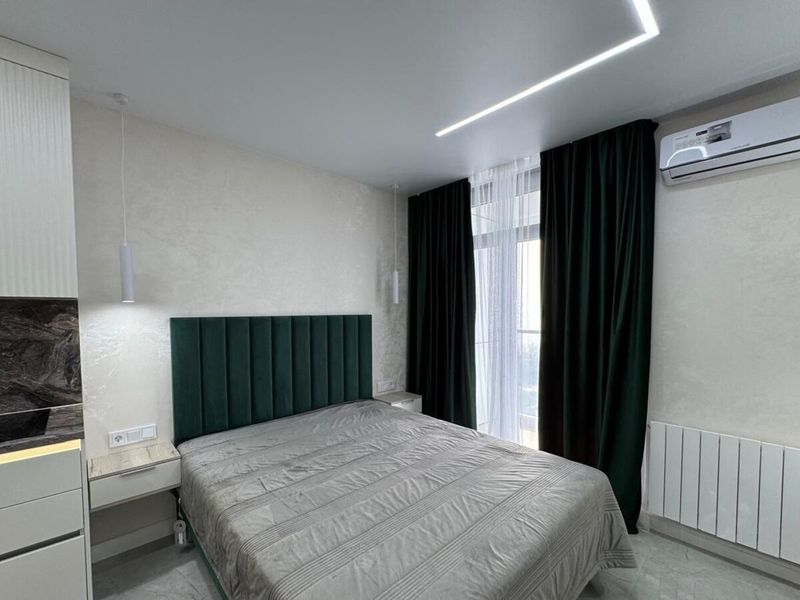 Bedroom with concealed LED lighting in the ceiling and behind the headboard