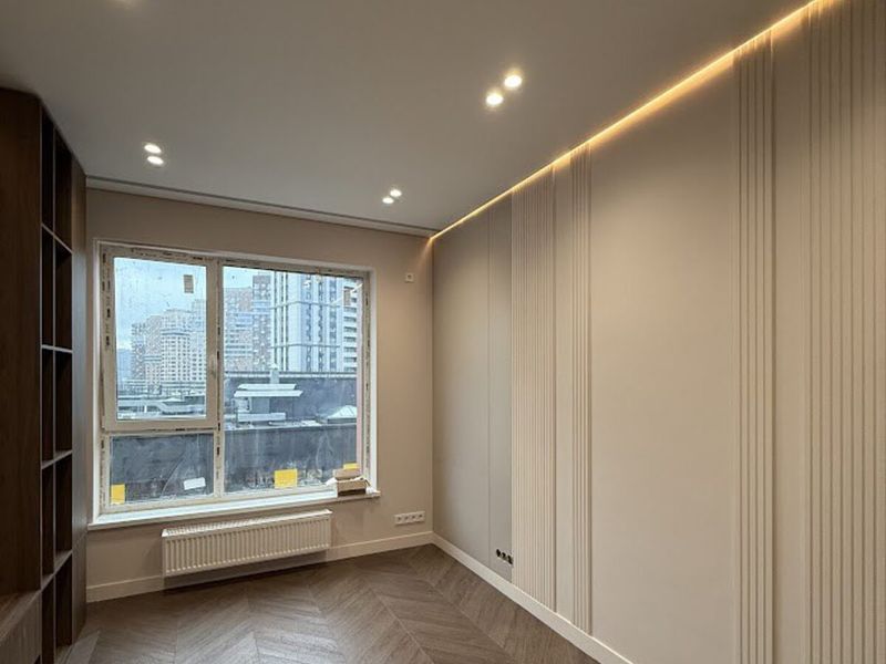 Smooth ceiling with recessed spotlights and hidden LED lighting
