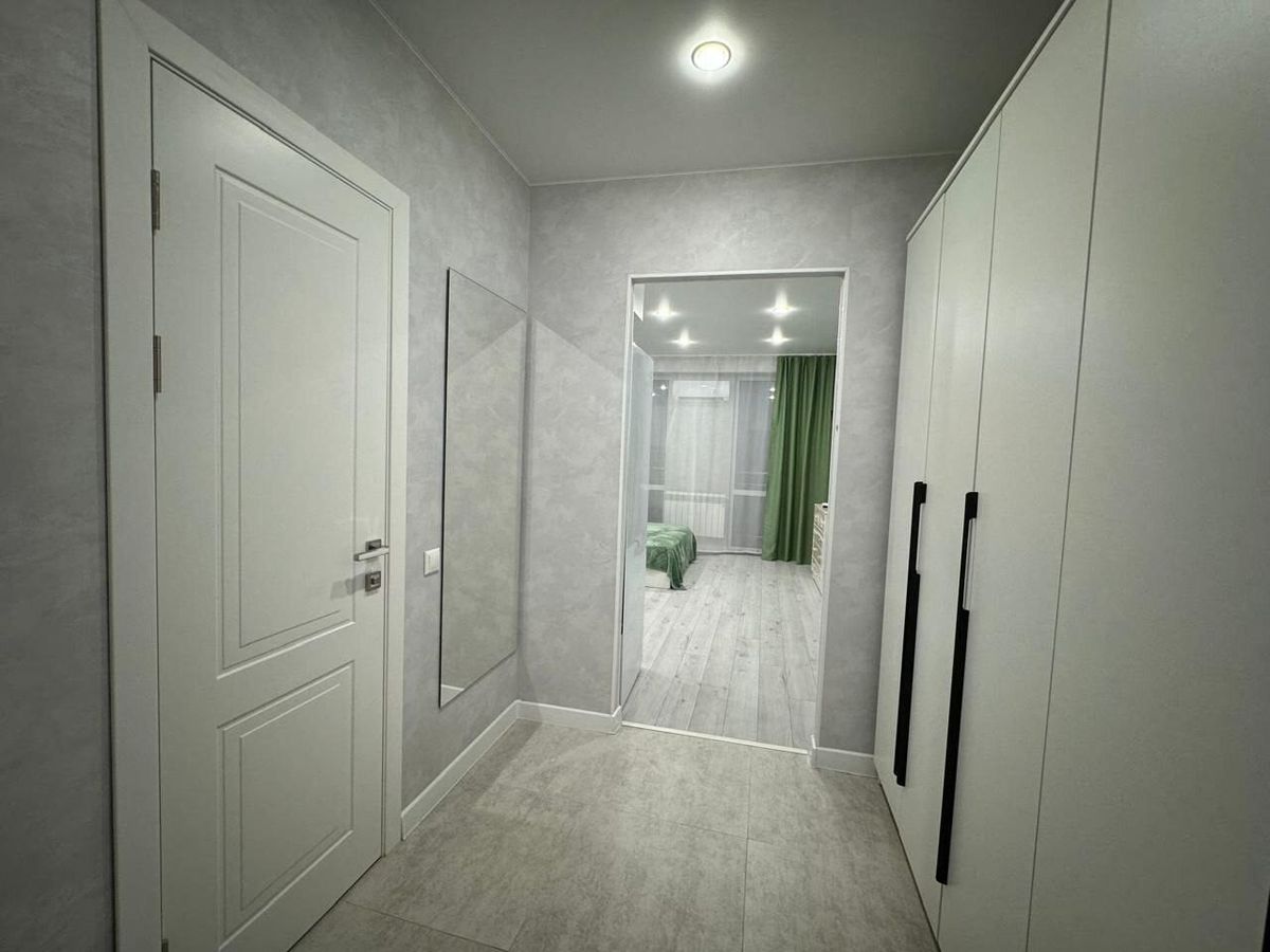 Hallway with a built-in wardrobe and a mirror after a studio apartment renovation