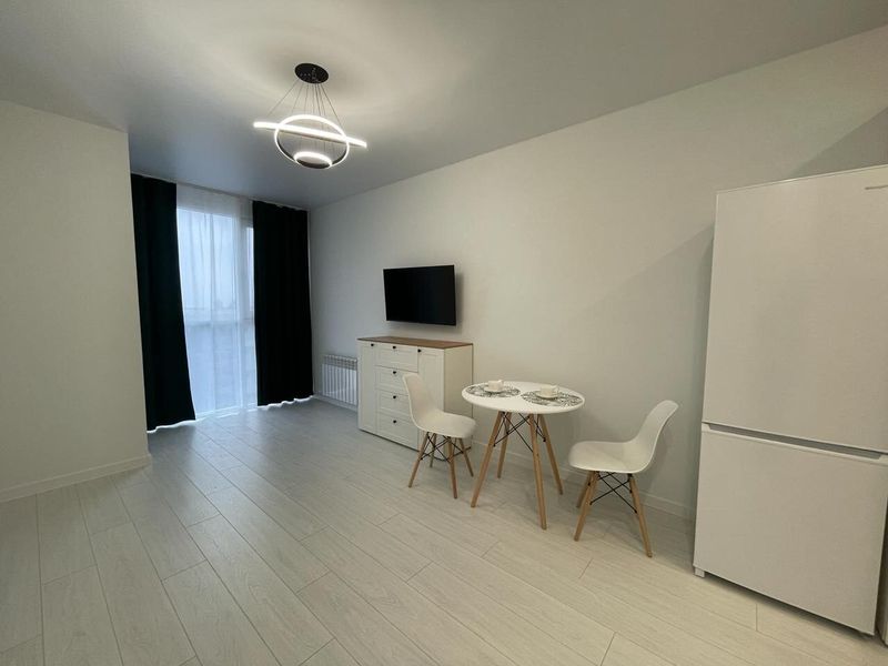 Obývací část garsoniéry po kompletní rekonstrukci – bílé stěny a světlá podlaha, Praha