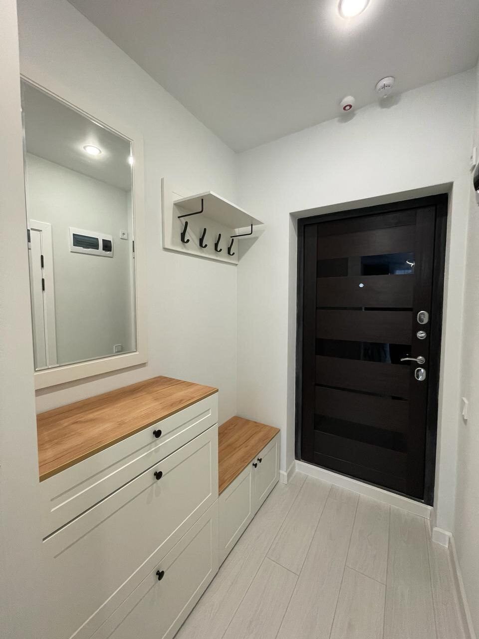 Hallway with a built-in wardrobe and wooden details after a studio renovation
