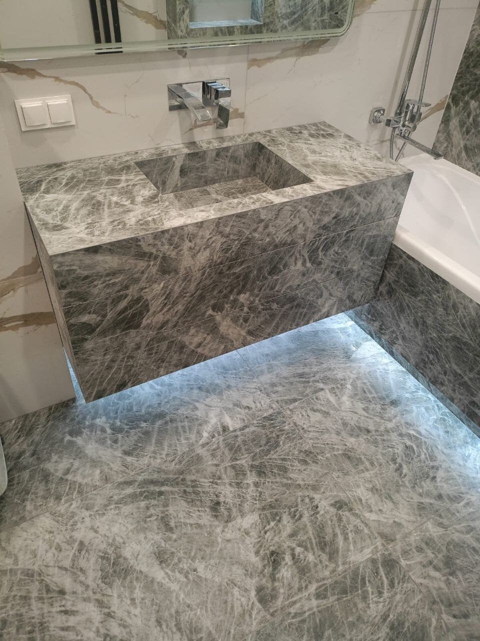 Floating marble counter with LED backlighting in a renovated bathroom