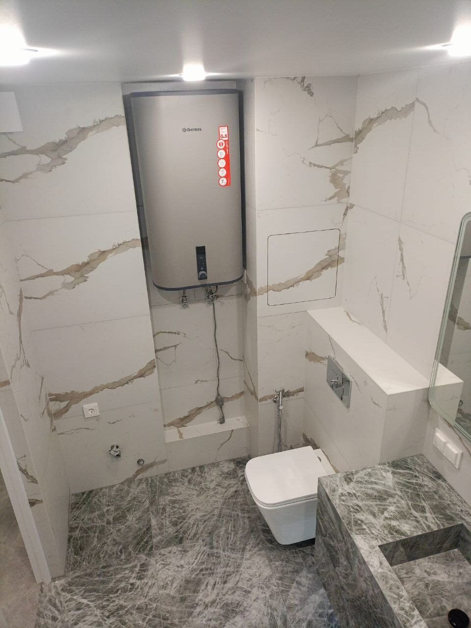 Wall-hung toilet and a new water heater after a complete bathroom renovation