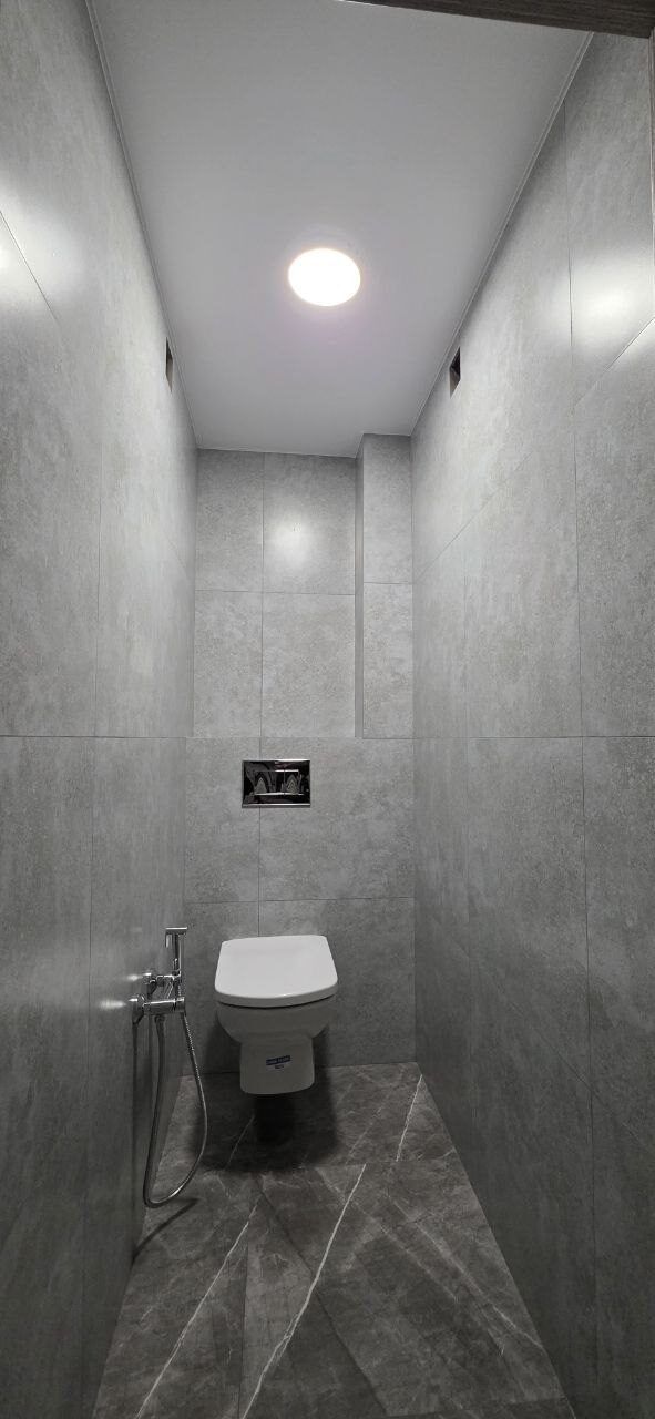Toilet room after renovation - concrete-effect finish and a wall-hung bowl